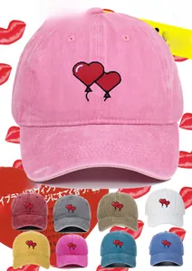 Detail of pink washed cotton baseball cap with red heart embroidery and color options