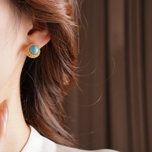 Detail of vintage 18k gold plated turquoise stud earring worn by a model