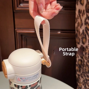 Detail of the portable woven strap on a stylish leopard print stainless steel vacuum flask