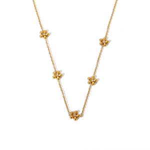Dettaglio di una collana in acciaio al titanio dorato con cinque piccoli ciondoli a margherita