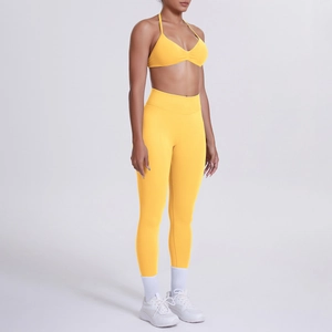 Vista laterale del set da yoga giallo brillante con leggings a vita alta e reggiseno sportivo