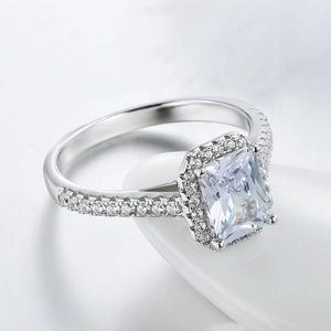 S925 sterling silver ring with emerald cut zircon and pavé halo on ceramic stand