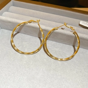 Macro view of 14k gold plated twisted hoop earrings on velvet jewelry display box