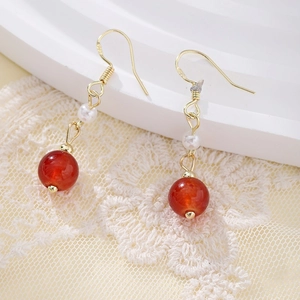 Detailed macro view of S925 silver ear hooks with elegant red beads and pearls