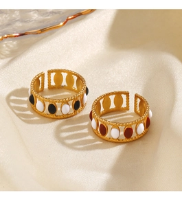 Detail view of gold open rings with enamel oval inlays on soft beige silk background