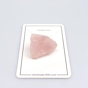 Macro shot of natural raw rose quartz stone displayed on a white Thank You card