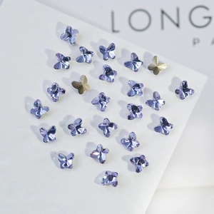 Macro shot of purple and gold butterfly crystal nail art charms for DIY decoration