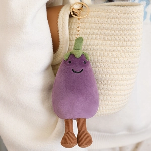 Cute plush eggplant keychain with long corduroy legs hanging on a white woven bag