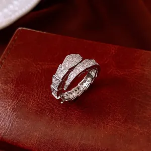 Bague serpent ouverte élégante avec écailles en zircone sur fond cuir sombre