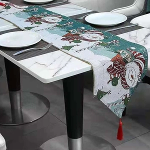 Christmas snowman embroidered table runner with red tassels on white marble table