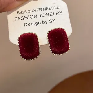 Macro shot of S925 silver needle square earrings with dark red velvet and gold twisted borders