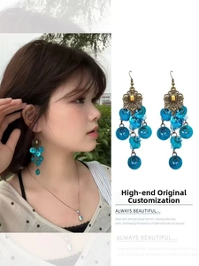 Close-up of bohemian bronze alloy earring and necklace set with blue resin charms