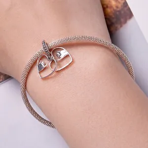 Silver mesh bracelet with a hollow heart charm showing a pinky promise handshake