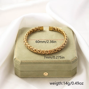 Close-up of golden titanium steel woven twisted bracelet with detailed metal texture