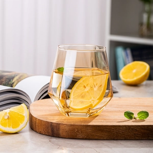Macro view of amber hexagonal glass on a wooden tray with fresh lemon slices