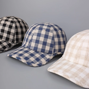 Detailed view of linen plaid baseball caps showing breathable fabric and stitching texture