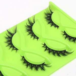 Detail view of 3 pairs of thick fox-eye false eyelashes with green tray and cat-eye curl