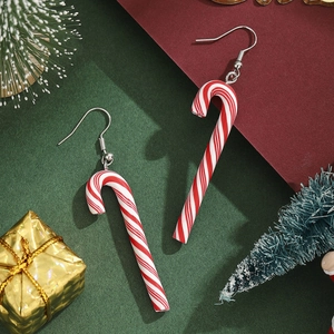 Nahaufnahme rot-weiß gestreifter Zuckerstangen-Ohrringe vor festlichem Geschenk-Hintergrund