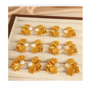 Detailed view of six vintage gold flower earrings with pearls on silk and wooden jewelry box
