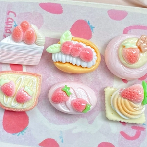 Flat lay of six diverse resin strawberry cake charms for hair clips and phone cases