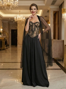 Close-up of black lace corset bodice and flowing satin skirt with a sheer mesh cape