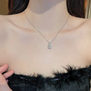 Détail du collier argenté avec pendentif calebasse serti de jade blanc et de diamants