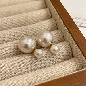 Elegant gold plated double sided pearl earrings on a premium linen display case