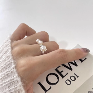 Detalle de tres perlas blancas graduadas engastadas en un anillo de plata S925