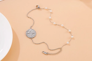 Detail of stainless steel double-layer bracelet with starburst pendant and white beads