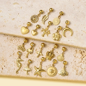 Pendentifs en acier titane doré avec étoile de mer et couronne sur pierre beige