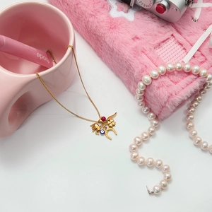 Detailed close-up of 18K gold stainless steel necklace with evil eye and horseshoe charms