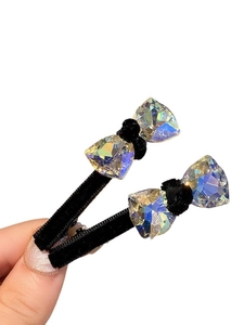Pair of black velvet bow hair clips with shimmering colorful rhinestones shown on hand