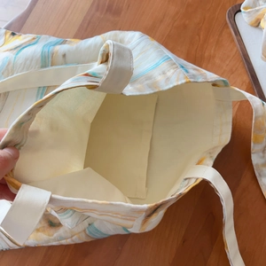 Internal view of canvas tote bag featuring watercolor patterns and an inner storage pocket