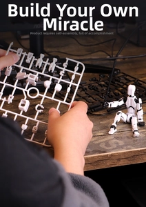 Detail view of white 3D printed robot parts and 13-jointed action figure on a desk