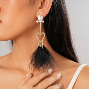 Long earrings with sparkling rhinestones and black feather tassels worn by a model
