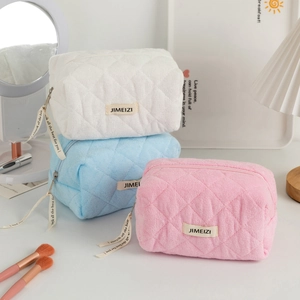 Quilted plush makeup bags in white, blue and pink colors with ribbon zipper puller