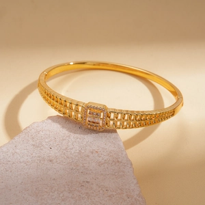 Détail d'un bracelet ajouré plaqué or 18 carats avec zircon sur support pierre