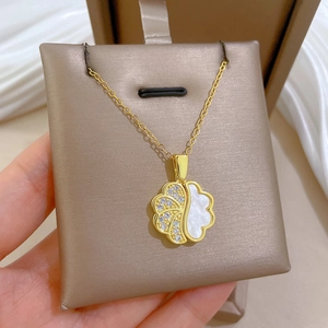 Detailed shot of gold necklace with fan-shaped pendant in white shell and crystals