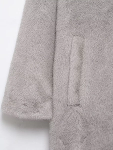 Close-up of the plush faux fur texture on grey winter coat sleeve and pocket details