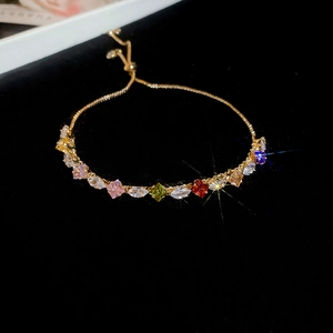 Macro detail of rainbow zircon bracelet with colorful teardrop stones and gold bolo clasp
