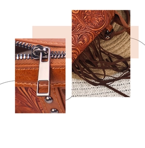 Detail of brown leather bohemian bag with floral embossing, tassels, and metal zipper