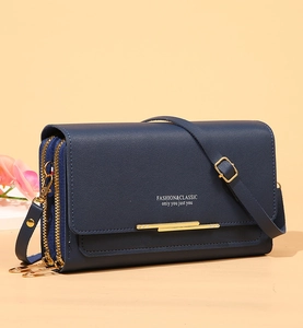 Detail view of dark blue leather crossbody wallet with gold metal bar and dual zipper compartments