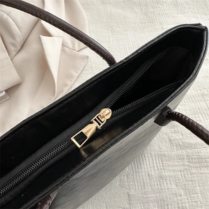 Classic black leather tote bag featuring a high-quality gold zipper and spacious interior