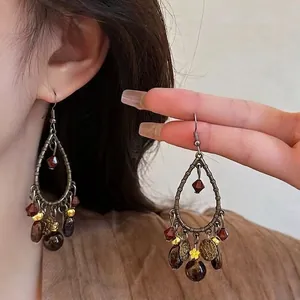 Detail of vintage bohemian drop earrings featuring wooden beads and yellow floral charms