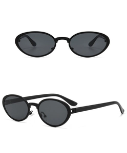 Detailed close-up of oval retro sunglasses with unique black textured grain frame finish