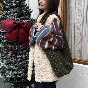 Close-up of fluffy dark green faux fur tote bag with white polka dots for winter style