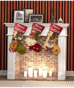 Three festive Christmas stockings with reindeer, Santa, and snowman on a white fireplace