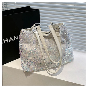Detail of silver iridescent sequin tote bag with white handles and metallic rings