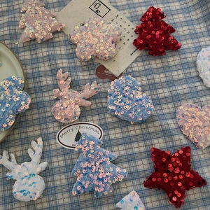 Macro shot of colorful sequined Christmas tree and reindeer fabric patches for DIY decor