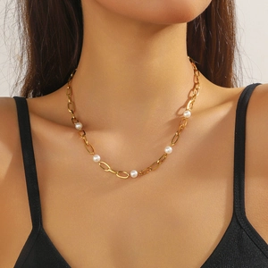 Détail d'un collier en acier inoxydable doré avec perles blanches porté par un mannequin